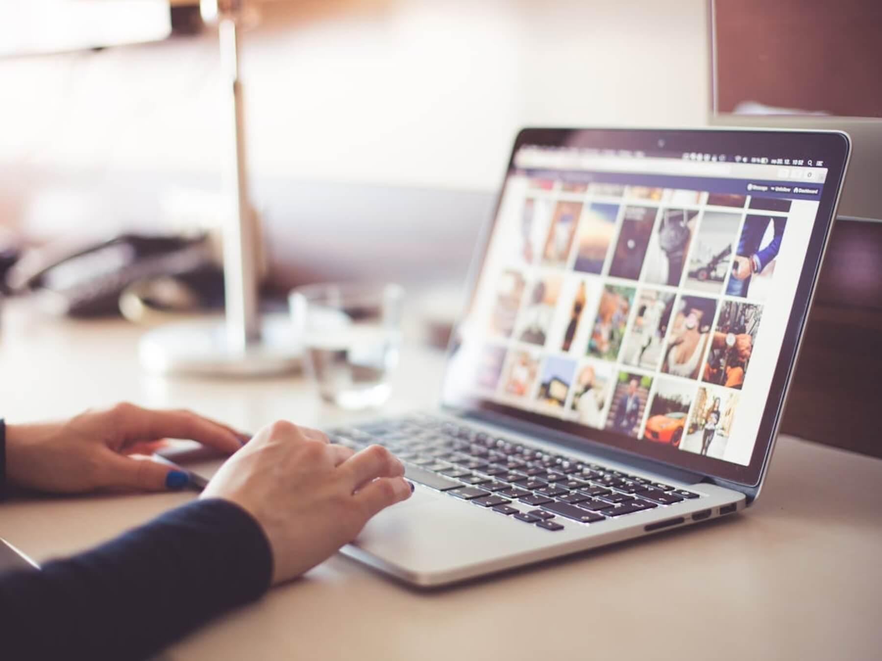 Person using a laptop and looking at images.